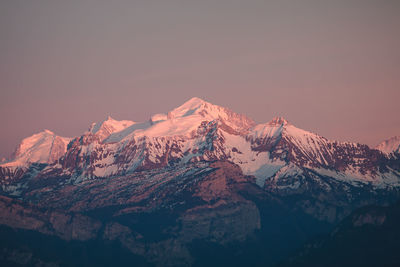 Scenic view of snowcapped mountains against sky during sunset