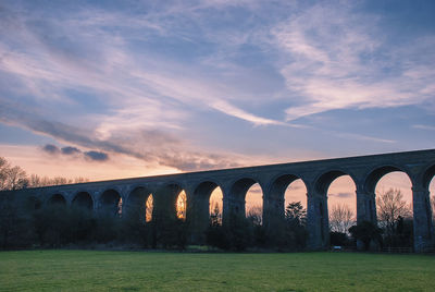 Arch bridge against sky during sunset