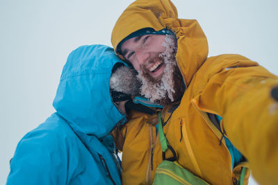 Portrait of smiling man standing on snow during winter