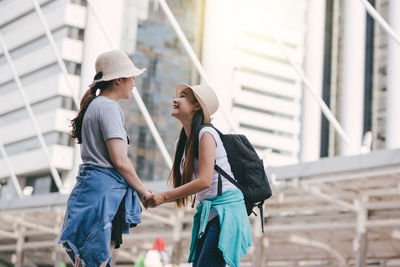 Tourists standing on footpath in city