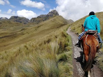 Rear view of man horse riding on mountain