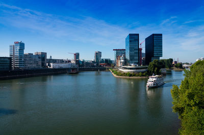 River amidst buildings in city against sky