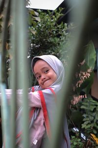 Portrait of smiling cute girl seen through plants