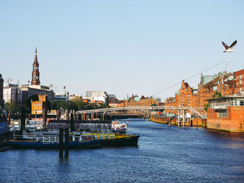 Scenic view of river by buildings against clear sky