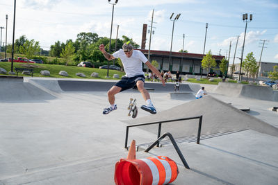 Full length of man skateboarding on skateboard against sky