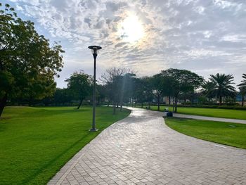 Street amidst trees in park against sky