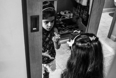 Rear view of girl looking at mirror