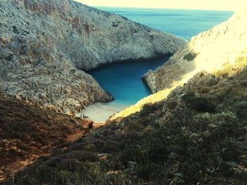 High angle view of rock formation by sea against sky