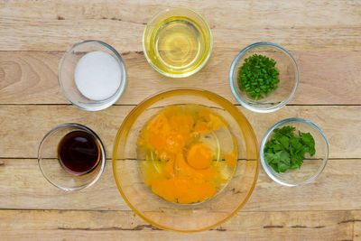 Directly above shot of egg yolks surrounded with various ingredients on table