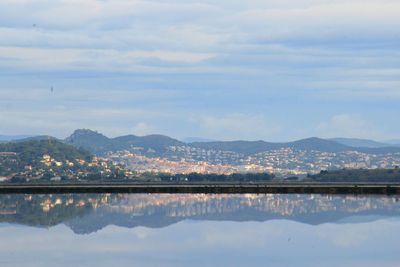 Scenic view of lake by mountains against sky