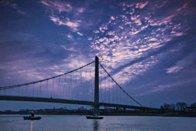 Bridge over river yangtze against cloudy sky during sunset