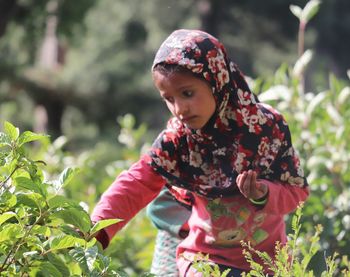 Close-up of girl looking at plants