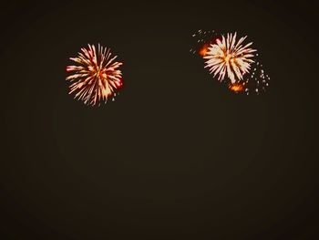 Low angle view of firework display at night
