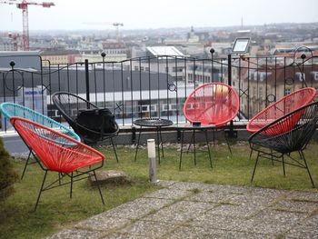 Empty chairs on field against sky