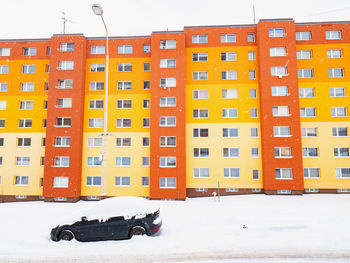 Snow covered residential buildings in city during winter