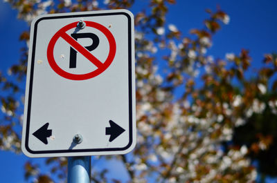 Low angle view of no parking sign against sky