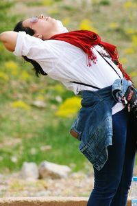 Woman stretching while standing on ground