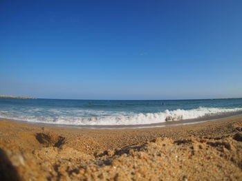 Scenic view of beach against clear blue sky