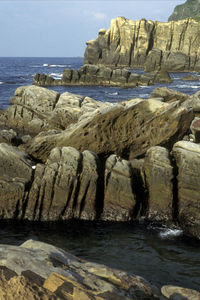 Rocks on beach against sky