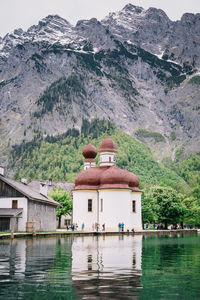 Built structure by lake and mountains