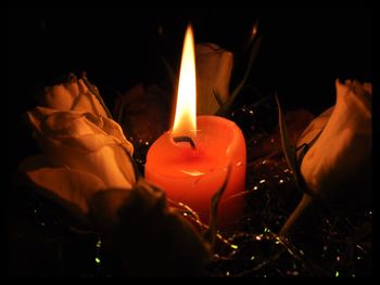 Close-up of lit candle in dark room