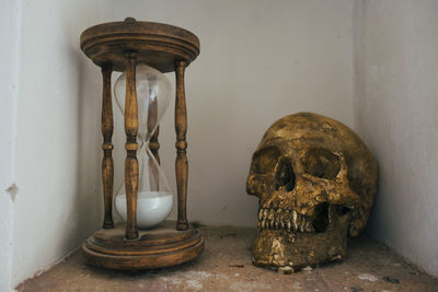 Close-up of human skull on table against wall