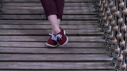 Low section of woman standing on wooden floor