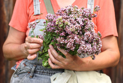 Midsection of man holding flower bouquet