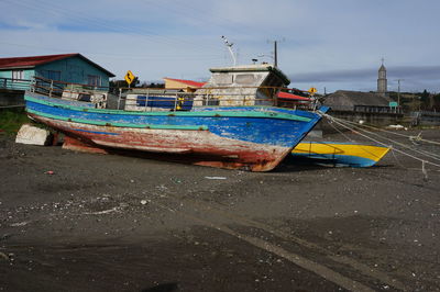 Boats moored at beach against sky