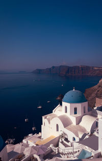High angle view of townscape by sea against clear sky