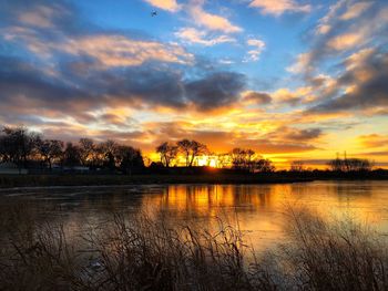Scenic view of lake against orange sky