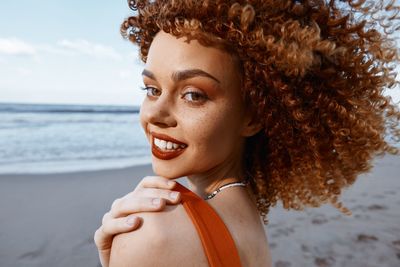 Portrait of young woman looking away at beach