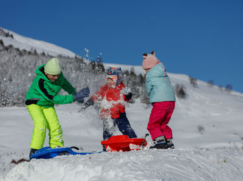 People skiing on snow covered landscape