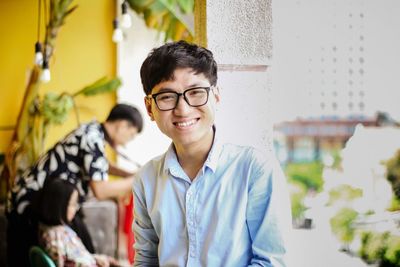 Portrait of smiling young man sitting at home