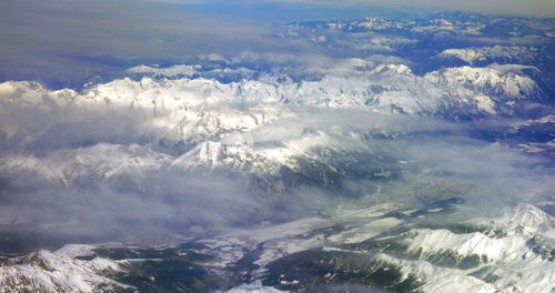 Aerial view of snowcapped mountains against sky