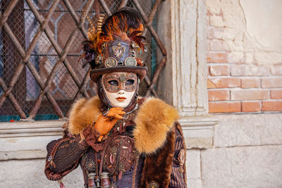 Portrait of person wearing mask against wall