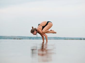 Full length of young woman in sea against sky