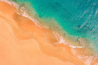 Aerial view of atlantic ocean coast with crystal clear turquoise water, waves rolling into the shore