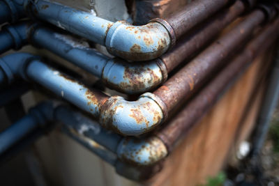 Close-up of rusty pipes mounted on wall