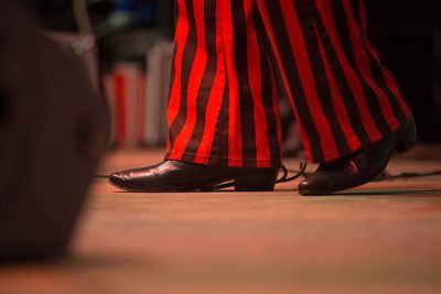 Low section of man with red umbrella