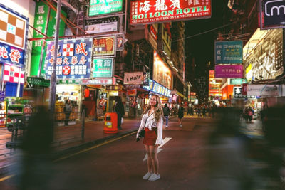 People walking on illuminated street at night