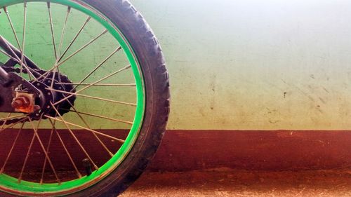 Close-up of bicycle wheel against wall