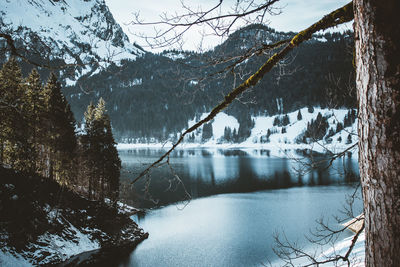 Scenic view of lake by snowcapped mountains during winter