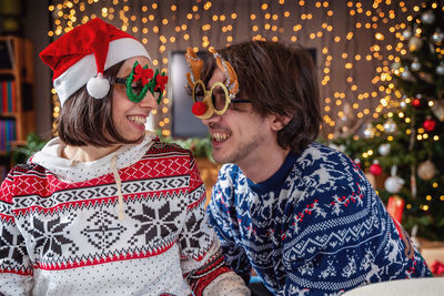 Young couple of lovers celebrating on christmas holy night - concept of christmas atmosphere