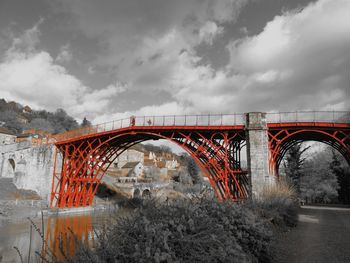 Arch bridge over river against sky