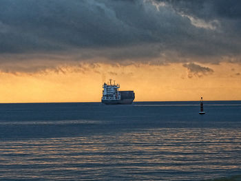 Sailboat sailing on sea against sky during sunset