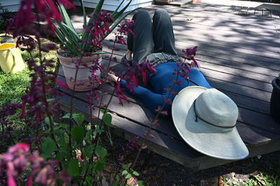 Rear view of woman sitting by potted plants