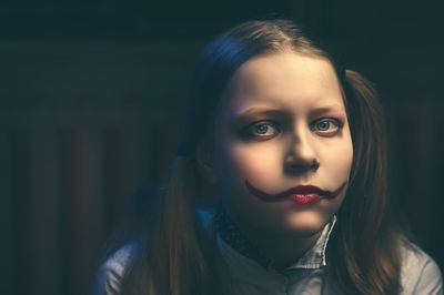 Portrait of teenage girl with face paint at home during halloween