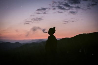 Silhouette man standing against sky during sunset
