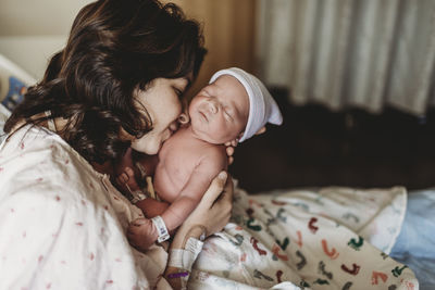 Close up detail of mother kissing newborn son in hospital